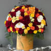 Large bouquet of red, yellow, orange, and white roses in a gold box