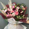 Bouquet of pink and burgundy roses with pampas grass and white wrap