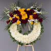 Standing floral wreath with red and yellow roses on an easel