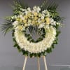 Large white floral wreath on a wooden stand