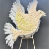 White feathered dove-shaped floral tribute on an easel