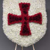 Heart-shaped floral tribute with a red cross on a white flower background