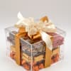 Clear gift box filled with assorted chocolates and topped with a cream ribbon bow