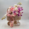 A charming baby girl gift arrangement designed in a stroller basket, filled