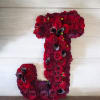 Floral arrangement shaped like the number 1 in deep red and burgundy blooms.