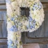 Large floral letter P made of white and pale blue flowers