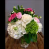 Bouquet of white, pink, and green flowers in a clear glass vase