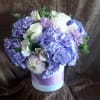 Lavender and white bouquet in a round pastel box