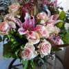 Pink roses and lilies arranged in a glass vase