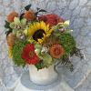 Mixed bouquet with sunflowers, roses, orchids, and dahlias in a white vase