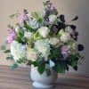 White and lavender floral arrangement in a white vase