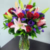 Bouquet of red roses and pink lilies in a glass vase
