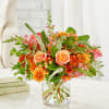 Orange and pink mixed bouquet in a clear glass vase