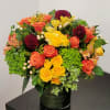 Colorful bouquet of roses, dahlias, and hydrangeas in a dark vase