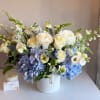 Blue and white floral arrangement in a white vase