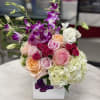 Mixed bouquet of roses, orchids, and hydrangeas in a white box