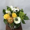 This arrangement features stunning pincushion proteas, mini green hydrangea, white anemones, yellow