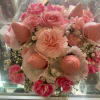 Pink bouquet with roses, carnations, and small white filler flowers