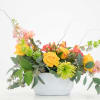 Yellow roses and mixed flowers in a white container