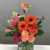 Bright mixed bouquet in a square glass vase with a balloon topper