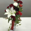 Red and white floral arrangement in a glittery high-heel vase with heart picks
