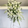 Tall white floral standing arrangement with roses and lilies on a metal easel