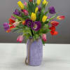 35 multicolor tulips in a handcrafted mason jar are jubilant in welcoming