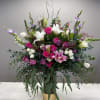 Large mixed bouquet of pink, white, and purple flowers in a gold vase
