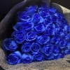 Bouquet of vivid blue roses wrapped in dark textured paper