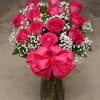 Pink roses with baby's breath in a glass vase and pink bow