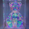 Iridescent geometric teddy bear figurine in a clear display box
