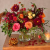 Mixed bouquet of roses and dahlias in a clear glass vase