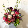 Tall mixed flower arrangement in a square silver vase