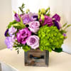 Purple and green floral arrangement in a wooden box