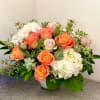Peach roses and white hydrangeas in a low vase arrangement