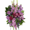Standing floral spray with purple and pink flowers on a white background