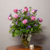 Pink roses and purple filler flowers in a glass vase