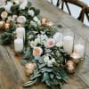 Floral table runner with white and blush blooms and glass candles