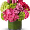 Pink and red roses with hydrangeas in a green glass vase