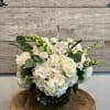 A lush cluster of white hydrangeas and garden roses creates the first