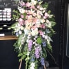 Large standing floral spray with pink lilies, roses, and purple flowers