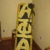 Tall floral standing tribute with yellow flowers spelling "SORRY"