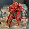 Gift basket wrapped in clear plastic with a large red decorative bow