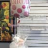 Baby bottle-shaped balloon above a diaper cake wrapped in clear plastic