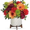 Colorful mixed bouquet in a white textured vase on a wooden stand