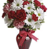Red and white mixed bouquet in a red vase with a polka-dot ribbon