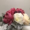 Pink and white peonies in a square glass vase with silver foliage