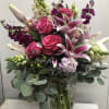 Pink roses and lilies arranged in a clear glass vase