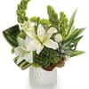 White lilies and green tropical flowers in a white vase
