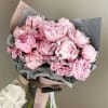 Bouquet of pale pink peonies wrapped in gray and blush paper